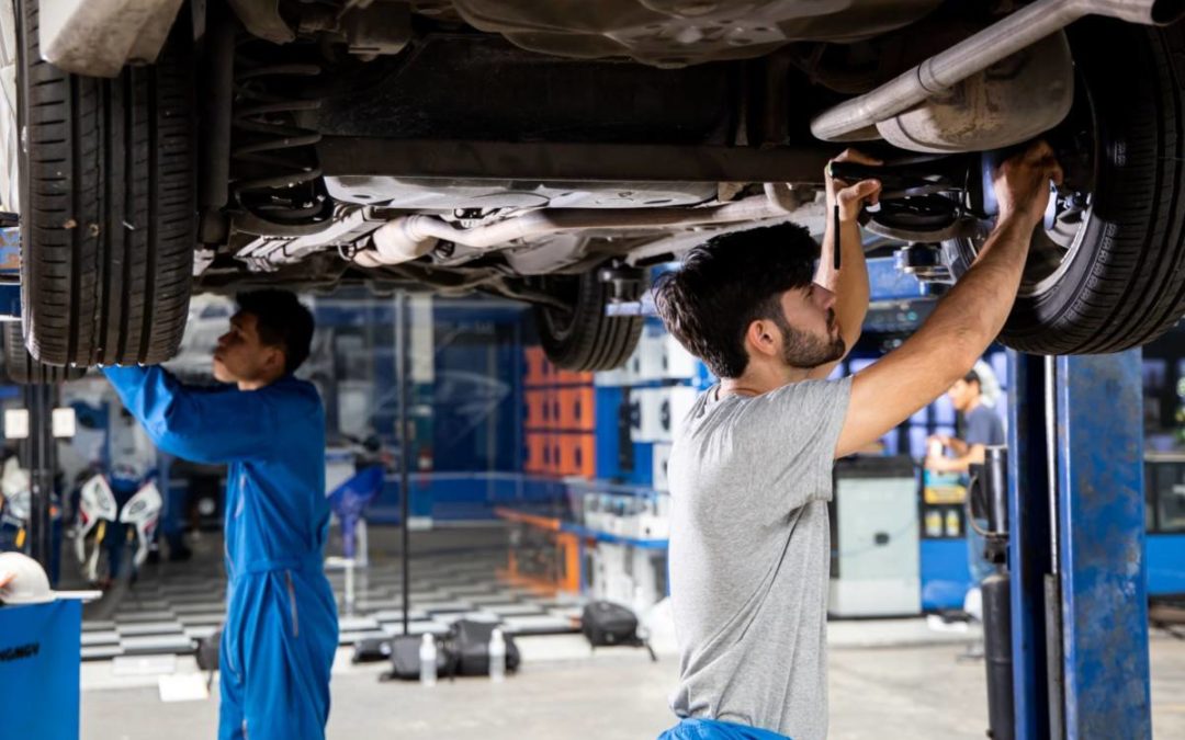 mechanics working on car suspension